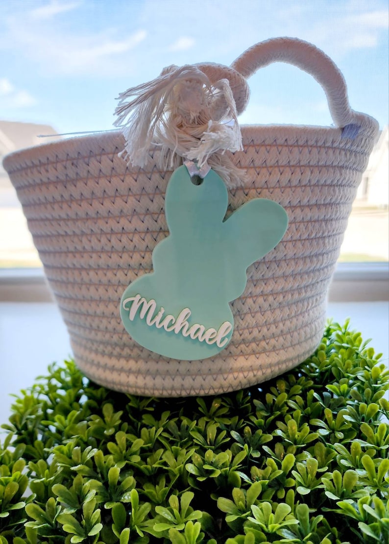 May include: A white rope basket with a light blue bunny-shaped tag that says "Michael".