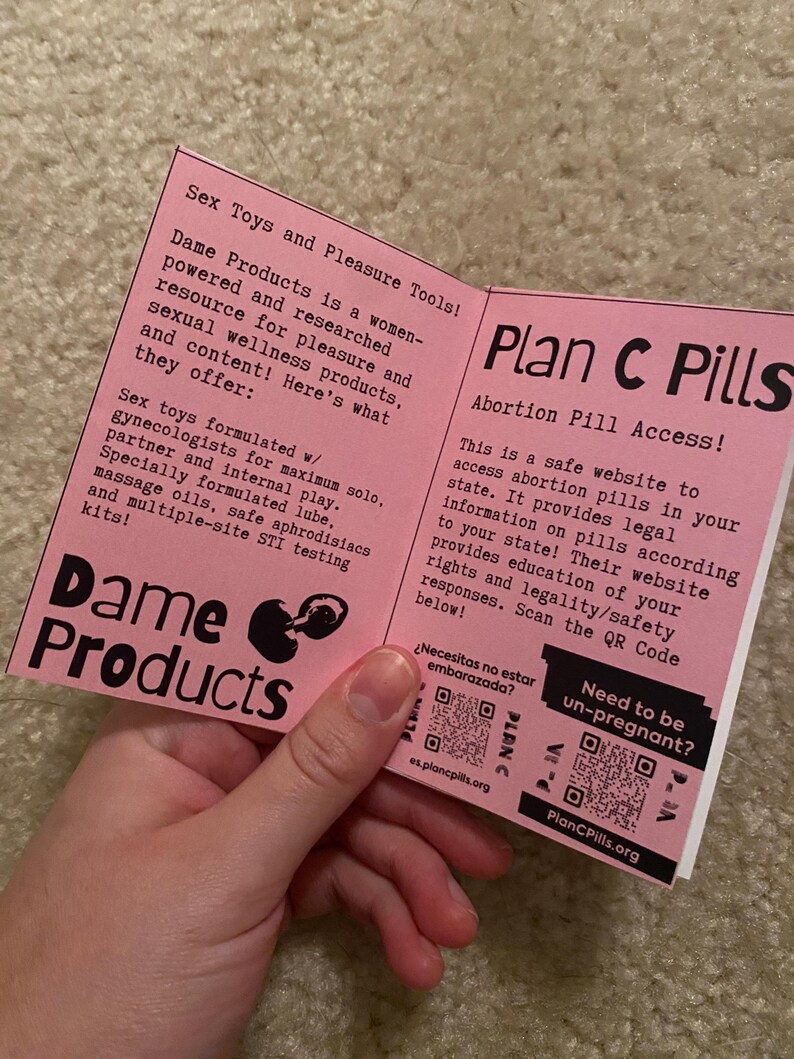 Puede incluir: Se muestra un folleto rosa con los t&iacute;tulos "Dame Products" y "Plan C Pills". El folleto proporciona informaci&oacute;n sobre productos de bienestar sexual y acceso a p&iacute;ldoras abortivas. El texto incluye direcciones de sitios web y c&oacute;digos QR.