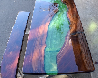 May include: A wooden table with a green epoxy river running through the center. The table is made of dark wood and has a high gloss finish. A matching bench is also included.