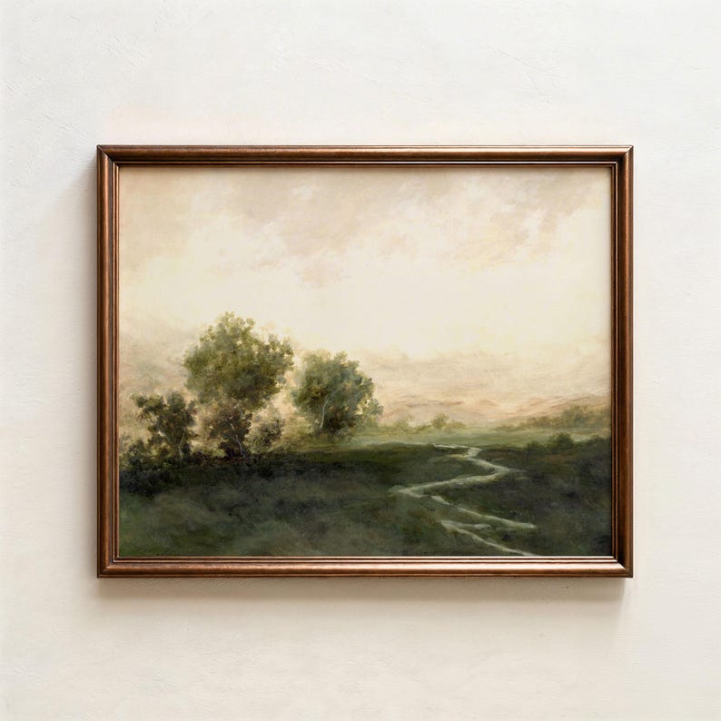 May include: A framed landscape painting with a bronze-colored frame. The artwork depicts a serene, misty scene with trees, a winding stream, and a soft, neutral sky. The color palette is dominated by greens, browns, and creams.