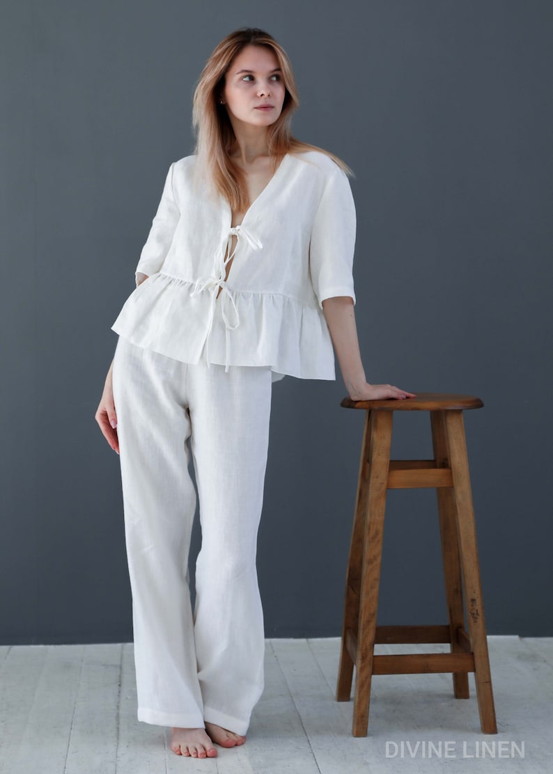 Puede incluir: Un conjunto de pijama de lino blanco con una parte superior con volantes y un lazo en el escote. Los pantalones son de pierna ancha y el conjunto est&aacute; hecho de lino suave y transpirable.