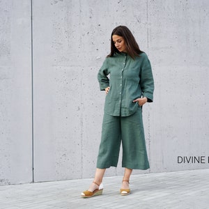 May include: A woman wearing a green linen shirt and matching pants. The outfit is a relaxed, casual style. The text "DIVINE LINEN" is visible in the bottom right corner of the image.
