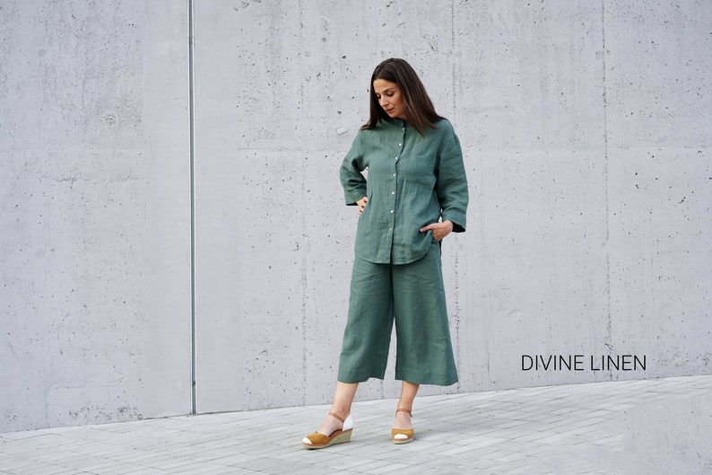 May include: A woman wearing a green linen shirt and matching pants. The outfit is a relaxed, casual style. The text "DIVINE LINEN" is visible in the bottom right corner of the image.