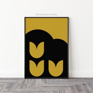 Peut inclure: Une impression d'art num&eacute;rique repr&eacute;sentant un motif abstrait noir et or avec trois tulipes stylis&eacute;es. L'impression est encadr&eacute;e dans un cadre noir et porte le texte "@bridgetfclarkstudio" en haut.
