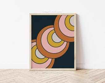 May include: Abstract geometric print featuring overlapping circles in shades of pink, orange, yellow, and grey against a dark blue background.