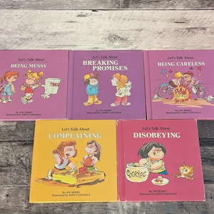 May include: Five children's books with titles such as "Being Messy," "Breaking Promises," and "Being Careless." The books feature colourful illustrations and are set against a wooden background. The author and illustrator's names are also visible.