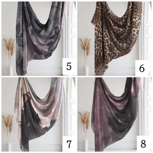 May include: Four different patterned scarves, two with abstract designs in shades of gray and pink, one with a leopard print, and one with a black and white abstract design.