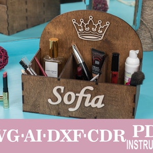 Op de afbeelding: Houten organizer met vakken voor make-up en toiletartikelen. De organizer heeft een kroonontwerp en de naam "Sofia" is gegraveerd op de voorkant.