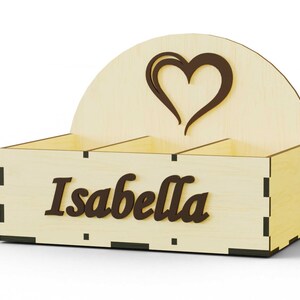 K&ouml;nnte beinhalten: Holzorganizer mit drei F&auml;chern, einem Herz-Ausschnitt und dem Namen "Isabella" auf der Vorderseite.