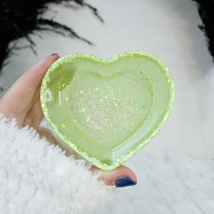 May include: A light green heart-shaped trinket dish with iridescent glitter embedded in the resin.