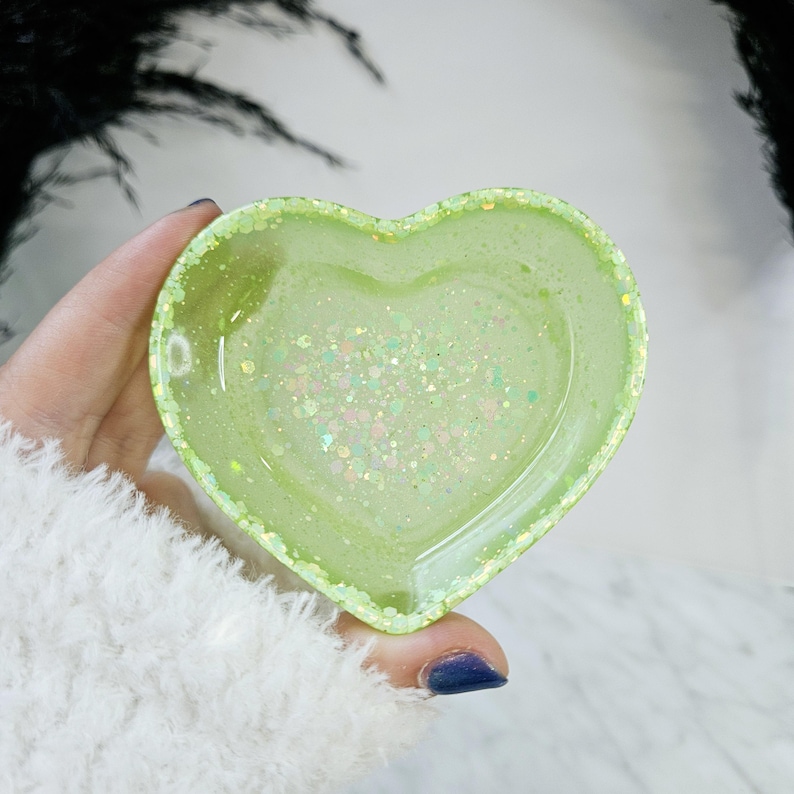 May include: A light green heart-shaped trinket dish with iridescent glitter embedded in the resin.