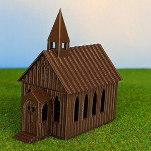 May include: A brown miniature church with a steeple, arched windows, and a cross detail. The model is set on a green surface, with a blue sky background. The church has a detailed, textured exterior.