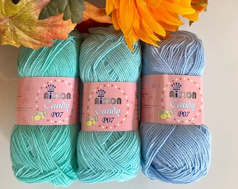 May include: Three balls of yarn in different colors: light blue, turquoise, and a darker turquoise. Each ball has a label that says "Aision Candy P07".