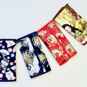 May include: Four fabric eyeglass cases with different patterns. One case is navy blue with Shiba Inu dogs, fans, and flowers. Another is navy blue with cranes and chrysanthemums. A red case features koi fish and gold accents. The last case has a forest scene.