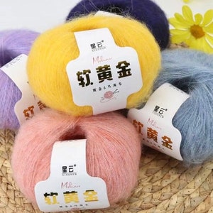Peut inclure: Quatre pelotes de laine de diff&eacute;rentes couleurs&nbsp;: jaune, rose, bleu clair et violet. La laine est douce et moelleuse, et les pelotes sont &eacute;tiquet&eacute;es avec le texte &laquo;&nbsp;Mohair Soft Gold&nbsp;&raquo; en caract&egrave;res chinois.