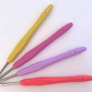 Pu&ograve; includere: Quattro ferri da uncinetto di diversi colori: giallo, rosa, viola e arancione. I ferri sono etichettati con le loro dimensioni: 2,0 mm, 2,25 mm, 2,5 mm e 2,75 mm.