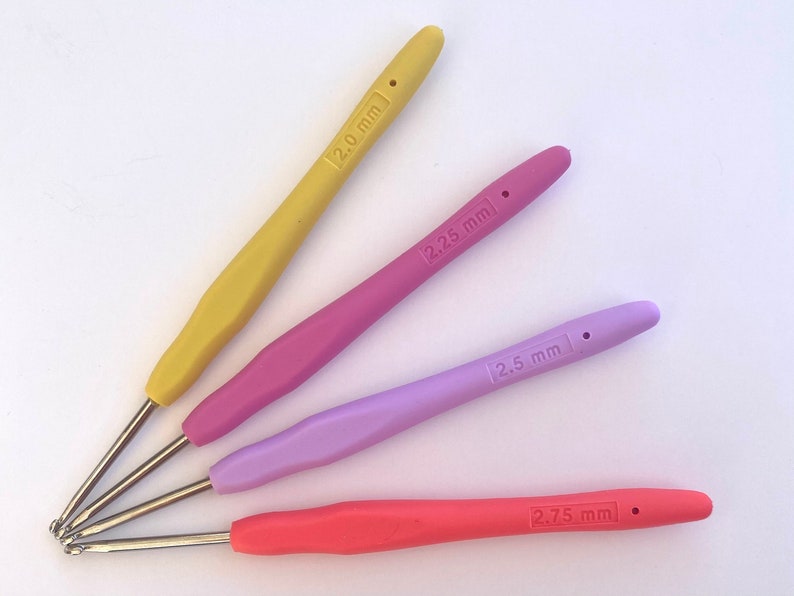 Pu&ograve; includere: Quattro ferri da uncinetto di diversi colori: giallo, rosa, viola e arancione. I ferri sono etichettati con le loro dimensioni: 2,0 mm, 2,25 mm, 2,5 mm e 2,75 mm.