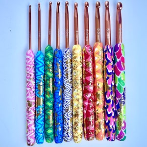 Puede incluir: Un juego de ocho agujas de crochet de colores con detalles dorados. Las agujas est&aacute;n hechas de metal y tienen una variedad de patrones en los mangos. Las agujas est&aacute;n etiquetadas con sus tama&ntilde;os en mil&iacute;metros: 3,5 mm, 4,0 mm, 4,5 mm, 5,0 mm, 5,5 mm, 6,0 mm, 6,5 mm y 7,0 mm.