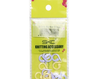 Può includere: Un pacchetto di 20 anelli marcapunti di colore viola e giallo per la maglia. La confezione è etichettata "Stitch Marker Rings" e ha un codice a barre. Il marchio è "SKC Knitting Accessory".