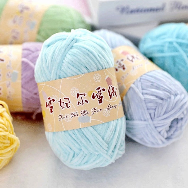 May include: A close-up of a light blue yarn ball with a label that reads "Xue Fei En Xue Dong". The yarn is soft and fluffy, and it is perfect for knitting or crocheting.
