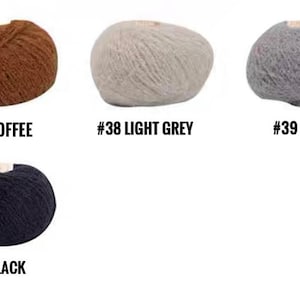 Puede incluir: Cuatro ovillos de hilo en diferentes colores: caf&eacute;, gris claro, gris y negro. Cada ovillo est&aacute; etiquetado con un n&uacute;mero y un nombre de color.