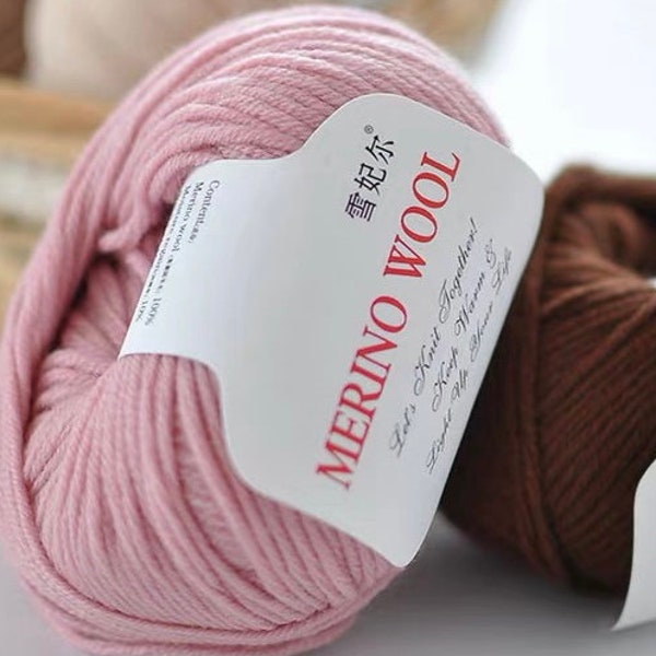 May include: Two skeins of yarn, one pink and one brown, with the label "Merino Wool" and the text "Let's Knit Together! Keep Warm &" in cursive. The label also includes the text "雪妃尔" in Chinese characters.
