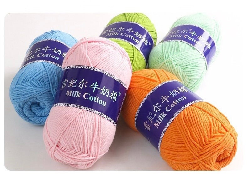 Pu&ograve; includere: Cinque gomitoli di lana in diversi colori: azzurro, rosa, verde, arancione e verde chiaro. Ogni gomitolo ha un'etichetta che dice "雪妃尔牛奶棉" e "Milk Cotton".