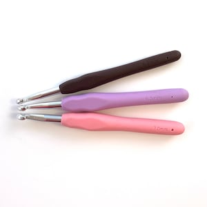 Pu&ograve; includere: Tre uncinetti con manici marroni, viola e rosa. Gli uncinetti sono etichettati con 6,5 mm, 7,0 mm e 8,0 mm.
