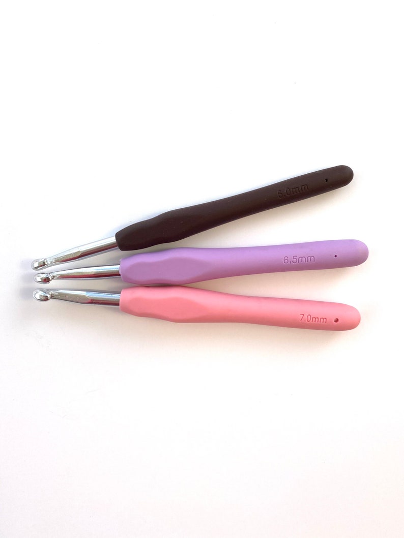 Pu&ograve; includere: Tre uncinetti con manici marroni, viola e rosa. Gli uncinetti sono etichettati con 6,5 mm, 7,0 mm e 8,0 mm.