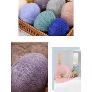 Peut inclure: Une collection de pelotes de laine color&eacute;es dans une bo&icirc;te en bois, avec une seule pelote de laine violette sur une surface en bois. La laine est douce et moelleuse, id&eacute;ale pour le tricot ou le crochet.