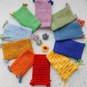 Pu&ograve; includere: Un set di dieci sacchetti con coulisse all'uncinetto in vari colori, tra cui blu, verde, giallo, arancione e rosso. I sacchetti sono disposti in cerchio su una superficie bianca.