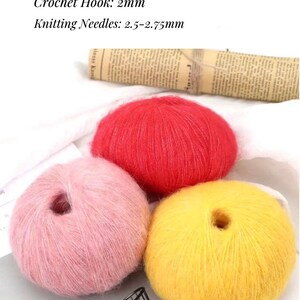 Peut inclure: Trois pelotes de laine en rose, rouge et jaune. Crochet : 2 mm Aiguilles &agrave; tricoter : 2,5-2,75 mm