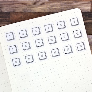 May include: White planner page with black and white numbered stickers from 1 to 18. The stickers are in a grid pattern and have a black outline with a white interior. The numbers are black and centered within the stickers.