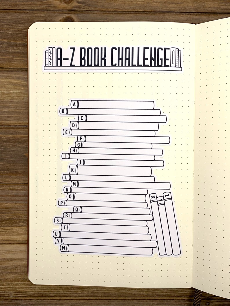 May include: A-Z Book Challenge checklist with blank spaces to fill in book titles. The checklist is designed to look like a bookshelf with a stack of books for each letter of the alphabet.