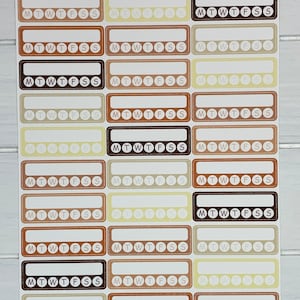 K&ouml;nnte beinhalten: Eine Sticker-Tabelle mit 18 w&ouml;chentlichen Habit-Tracker-Stickern. Die Sticker sind in verschiedenen Braunt&ouml;nen, Beige- und Cremet&ouml;nen gehalten. Jeder Sticker hat eine rechteckige Form mit einem Rand und dem Text "MTWTFSS" in der Mitte. Der Text "Weekly Habit Trackers | Light Academia" befindet sich oben auf der Tabelle. Der Text "STICKER SHEET" befindet sich unter dem Titel. Der Text "STI-363 Purple Pisces Creations purplepiscescreation.etsy.com" befindet sich unten auf der Tabelle.