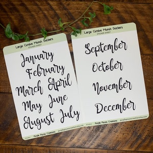 May include: Two sticker sheets with cursive month names in black ink. The first sheet displays January through July, and the second sheet shows September through December. The text "Large Cursive Month Stickers" is printed at the top of each sheet.