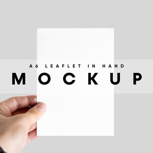 May include: A hand holding a blank A6 leaflet mockup. The text "A6 Leaflet in Hand Mockup" is printed on a white strip below the leaflet.