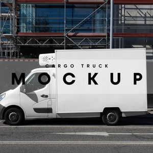 May include: A white cargo truck with the text "CARGO TRUCK MOCKUP" on the side. The truck is parked on a street in front of a building under construction.