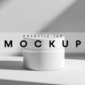 May include: White cosmetic jar mockup on a white surface with a shadow. The text "COSMETIC JAR MOCKUP" is displayed above the jar.