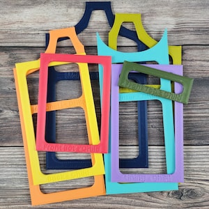 May include: A set of colorful plastic frames with the text "Front & Back Child" and "Turning Child" printed on them. The frames are arranged in a stack on a wooden surface.