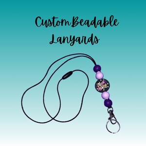 May include: A black beaded lanyard with a purple and white bead charm that says "Spook Babe".