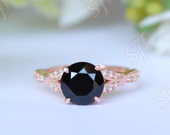 May include: A rose gold engagement ring with a black diamond center stone and a pave diamond band.