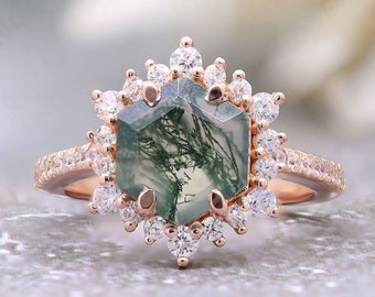 Può includere: Un anello in oro rosa con una pietra esagonale di agata verde muschio circondata da un'aureola di piccoli diamanti rotondi.