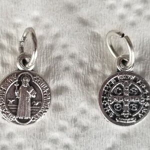 Peut inclure: M&eacute;daille de Saint Christophe en argent avec une boucle en argent. Le recto de la m&eacute;daille repr&eacute;sente Saint Christophe portant un enfant. Le verso de la m&eacute;daille repr&eacute;sente une croix avec l'inscription "S.P.Q.R."