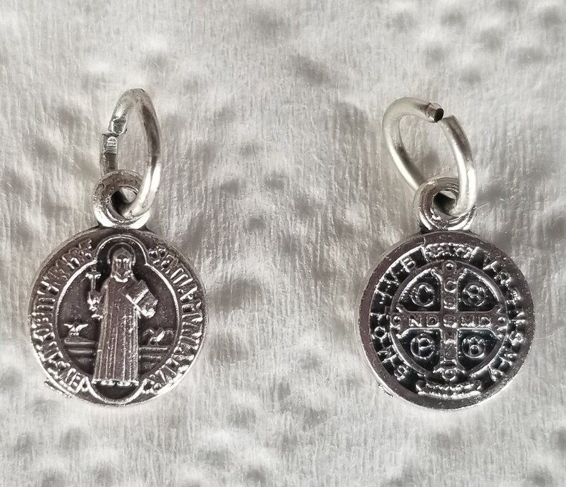 Peut inclure: M&eacute;daille de Saint Christophe en argent avec une boucle en argent. Le recto de la m&eacute;daille repr&eacute;sente Saint Christophe portant un enfant. Le verso de la m&eacute;daille repr&eacute;sente une croix avec l'inscription "S.P.Q.R."