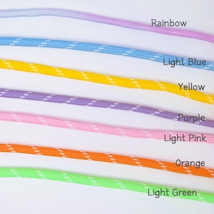 May include: Seven parallel lengths of braided cord arranged horizontally. The colors from top to bottom are labeled as Rainbow, Light Blue, Yellow, Purple, Light Pink, Orange, and Light Green. Each cord features a repeating white diagonal pattern.