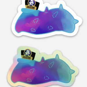 May include: Two stickers of a purple and blue sea slug with a gold and black hat that says "SUGAR BEARS" on it. The sea slug is a cartoon style illustration with a galaxy pattern.