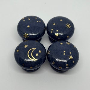 May include: Four dark blue wooden knobs with gold crescent moon and star designs.