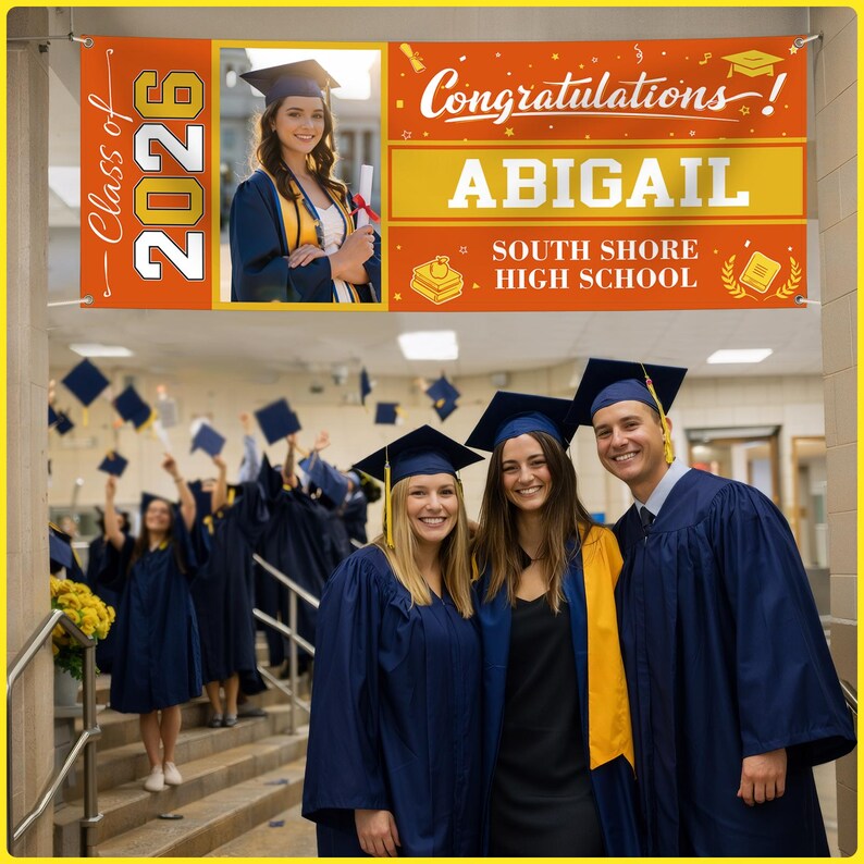 May include: A graduation banner with the text "Class of 2026" and "Congratulations!" is displayed above a group of graduates. The banner also includes the name "ABIGAIL" and "SOUTH SHORE HIGH SCHOOL". Graduates are wearing blue gowns and caps.