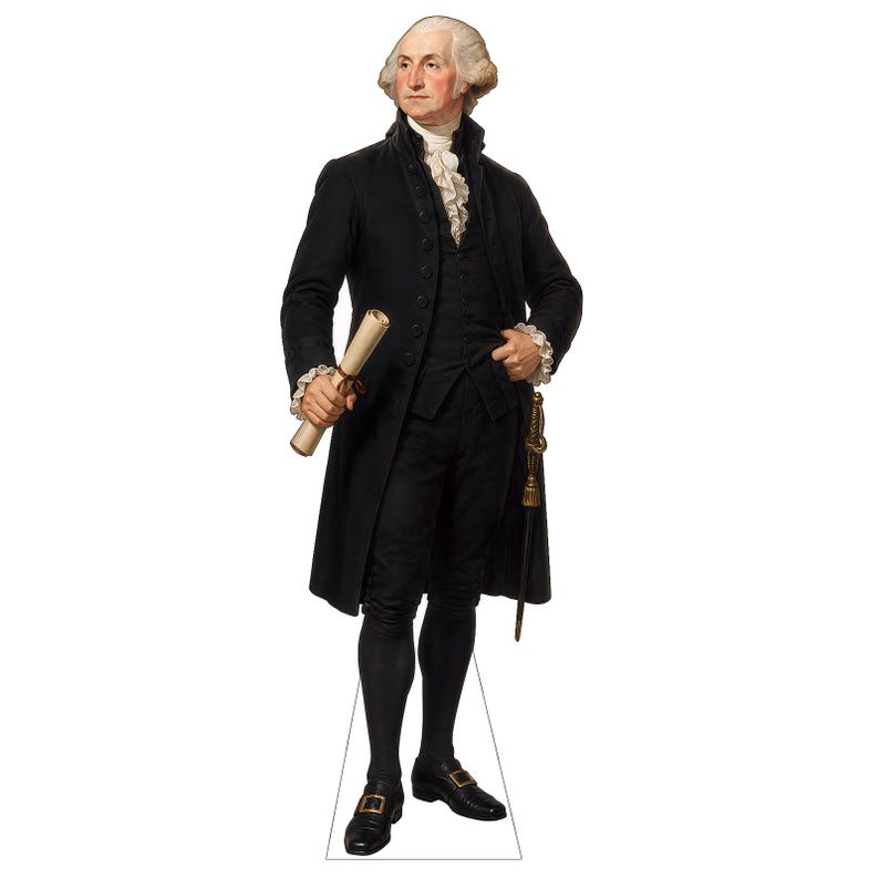 May include: A life-sized cardboard cutout of George Washington wearing a black coat, vest, and breeches with a white ruffled cravat and cuffs. He holds a rolled document in his right hand and has a sword hanging at his left side.